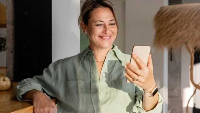 Mujer sonriendo mientras realiza una videollamada con su teléfono móvil. (Foto: Freepik)